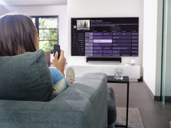 Użytkownik sterujący Apple TV pilotem One For All URC 1110 z kanapy